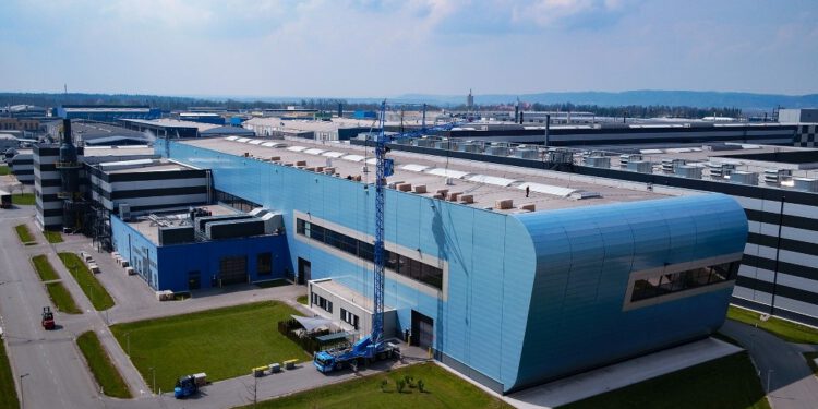 Zum Projektstart werden erste Bauteile der neuen Photovoltaikanlage auf das Dach des neuen AMAG-Kaltwalzwerks gehoben.