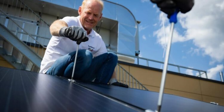 Mann montiert PV-Anlage